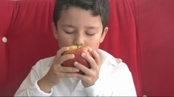 Niño comiendo manzana roja — Vídeo de stock