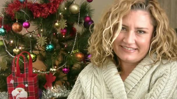 Portret van een lachende vrouw en de kerstboom — Stockvideo