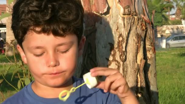 Niño soplando burbujas — Vídeos de Stock