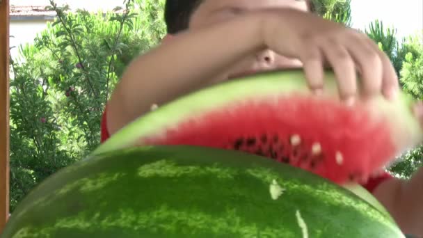 Liten pojke äter vattenmelon — Stockvideo