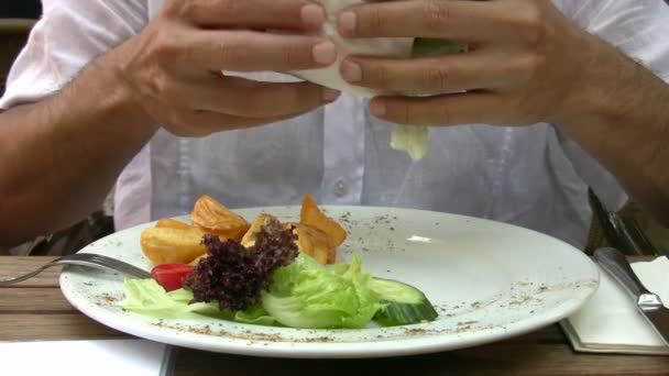 Homem comendo hambúrguer — Vídeo de Stock