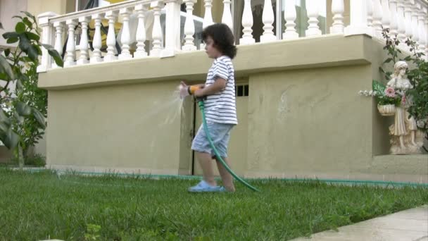 Kleiner Junge gießt Garten — Stockvideo