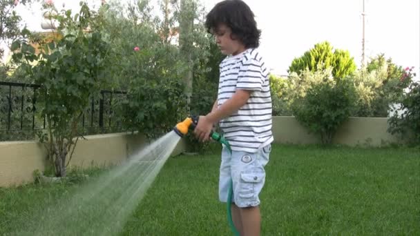 Kleiner Junge gießt Garten — Stockvideo