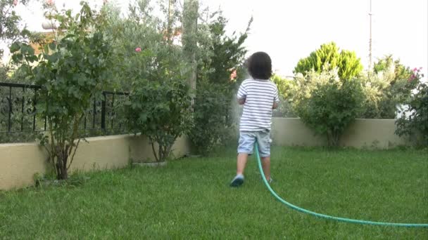 Malý chlapec zalévání zahrada — Stock video