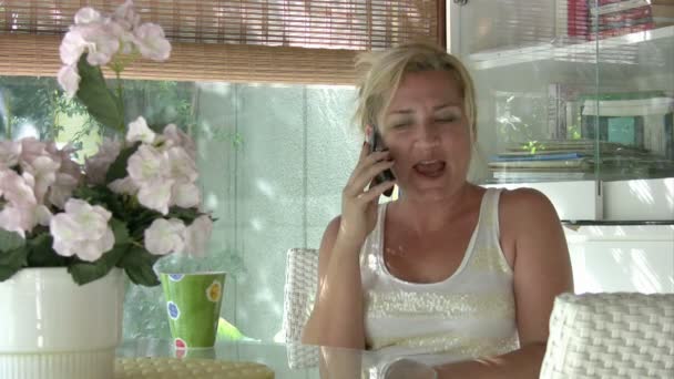 Kobieta rozmawiająca przez telefon komórkowy i pijąca kawę — Wideo stockowe
