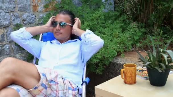 Homme relaxant dans le jardin — Video