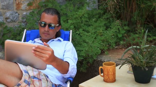 Человек с помощью цифрового планшета в саду — стоковое видео