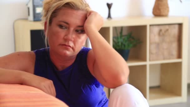 Triest vrouw zitten op een sofa — Stockvideo