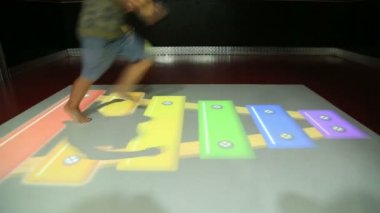 Bilgisayar projeksiyon oyunları ile oynayan çocuk
