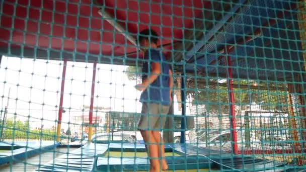 Mały chłopiec skoki na trampolinie — Wideo stockowe