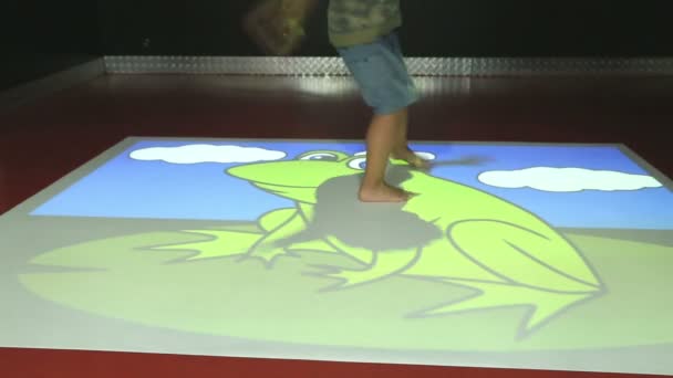 Enfant jouant avec des jeux de projection informatique — Video