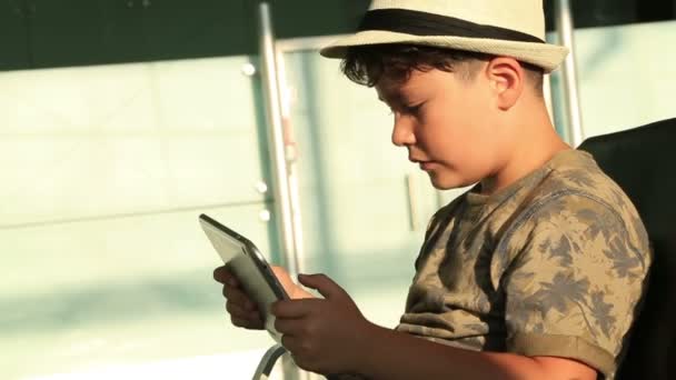 Niño con sombrero usando i pad — Vídeo de stock