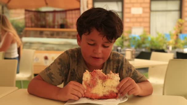 Lindo chico comiendo pizza en el restaurante 2 — Vídeo de stock