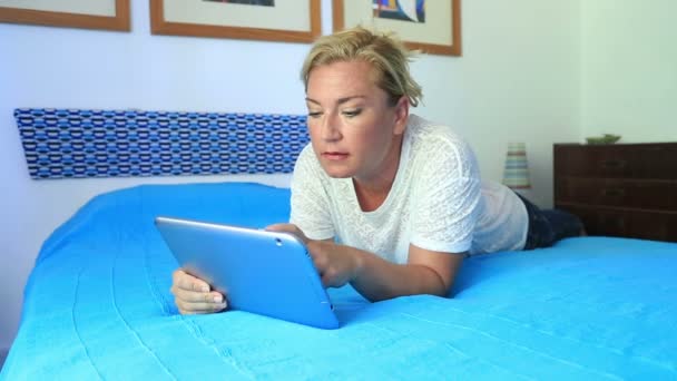 Frau liegt auf Bett und nutzt digitales Tablet — Stockvideo