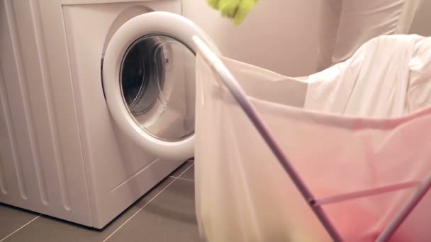 Mulher colocando roupas em uma máquina de lavar roupa — Vídeo de Stock