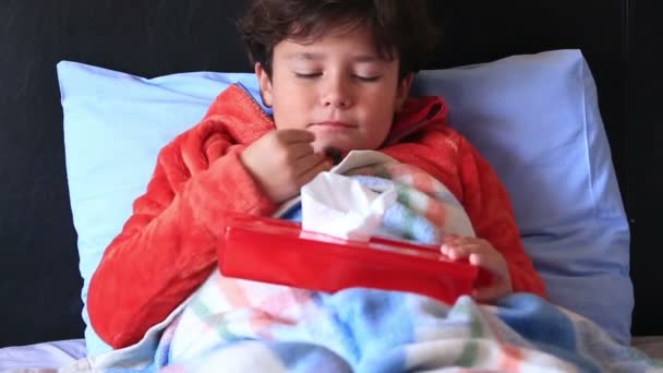 Sick child in bed sneezing — Stock Video