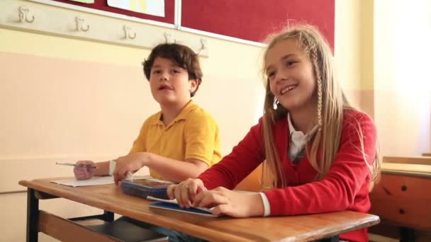 Χαμογελώντας μαθητών που εργάζονται μαζί σε μια σχολική τάξη — Αρχείο Βίντεο