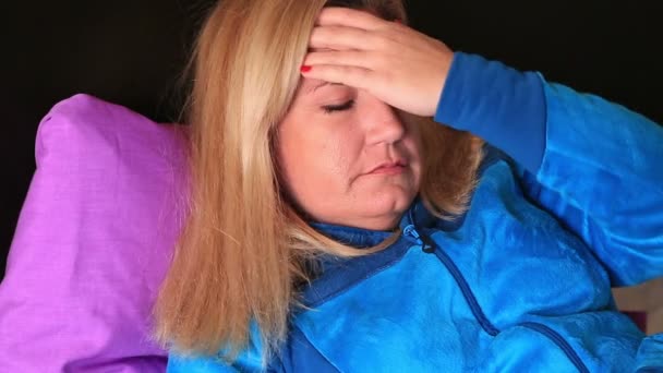 Zieke vrouw liggen op een bed en hebben van hoofdpijn — Stockvideo