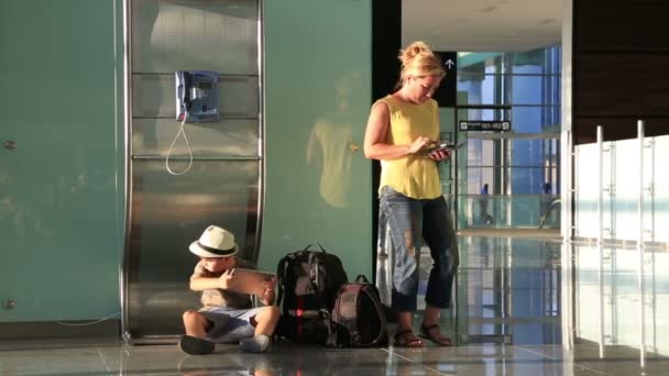 Mutter und ihr kleiner Junge warten am Flughafen — Stockvideo