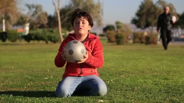 Bir kameraya gülümseyen bir top ile mutlu bir çocuk portresi — Stok video