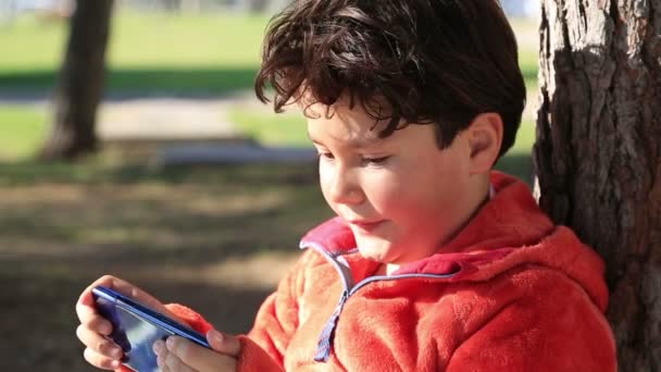 Jeune garçon jouant sur téléphone intelligent — Video