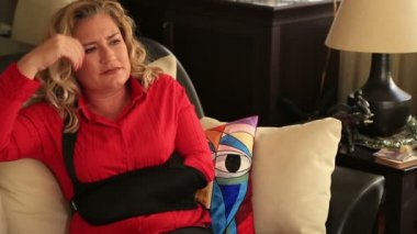 Kırık bir kol kol küme ayracı giyen acı veren kadınla