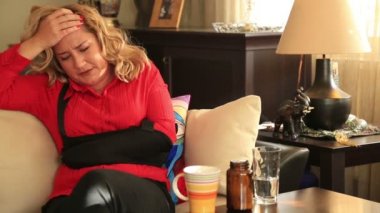 Kanepede oturan ve acı kolunu dokunmadan kadın