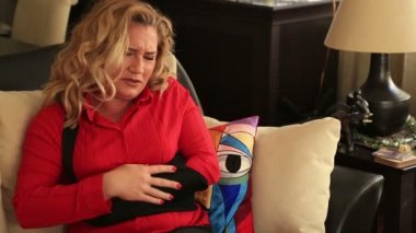 Kanepede oturan ve acı kolunu dokunmadan kadın