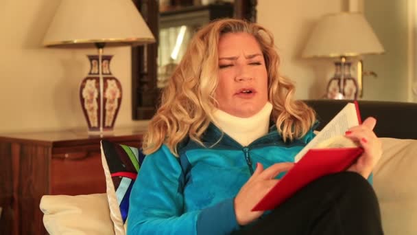 Painful woman with neck brace reading a book — Stock Video