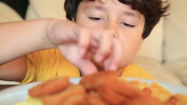 Çıtır soğan halkaları ve patates kızartması yiyen çocuk