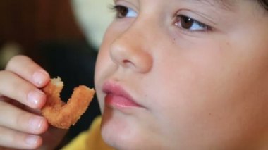 Çıtır soğan halkaları ve patates kızartması yiyen çocuk