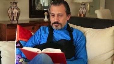 Kırık bir kol kol küme ayracı giymiş olan acı adam