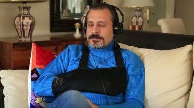 Kırık bir kol kol küme ayracı giymiş olan acı adam