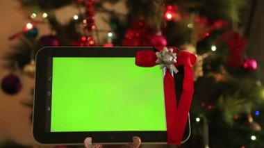 Yeşil ekran dijital tablet ile Noel ağacı ışıkları arka plan