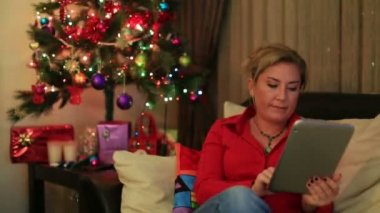 Noel ağacı yakınındaki gülümseyen bir kadın portresi