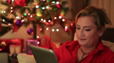 Noel ağacı yakınındaki gülümseyen bir kadın portresi