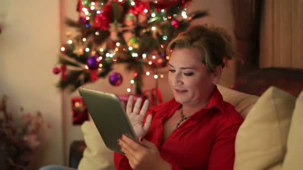 Портрет женщины, сидящей возле рождественской елки — стоковое видео