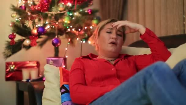 Portrait d'une femme assise près du sapin de Noël — Video