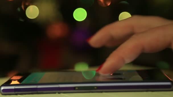 Mãos de mulher usando telefone inteligente móvel com fundo bokeh luz colorida close-up — Vídeo de Stock