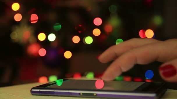 Vrouw handen met behulp van mobiele slimme telefoon met kleurrijke licht bokeh achtergrond-close-up — Stockvideo