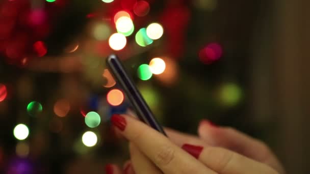 Les mains de la femme en utilisant un téléphone intelligent mobile avec fond bokeh lumière colorée- gros plan — Video