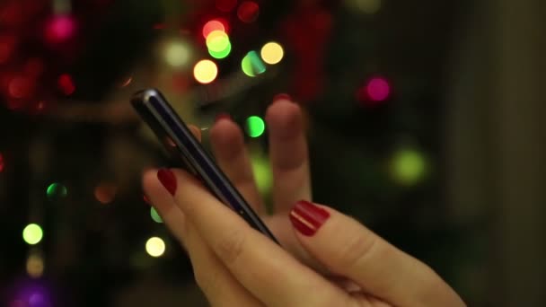 Женщина руки с помощью мобильного смартфона с красочным светом bokeh фона-крупным планом — стоковое видео