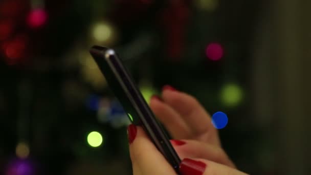 Las manos de la mujer usando el teléfono inteligente móvil con fondo bokeh luz colorida-primer plano — Vídeos de Stock