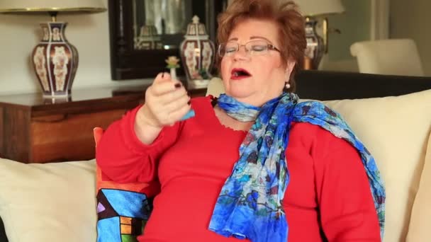 Зрелая женщина, использующая ингалятор от астмы — стоковое видео