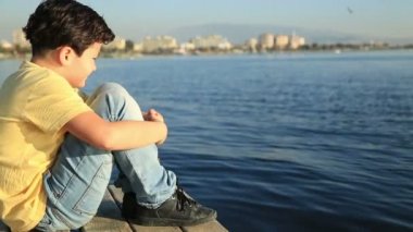 Ahşap bir iskele üzerinde genç çocuk