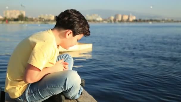 Молодий хлопчик на дерев'яній набережній — стокове відео