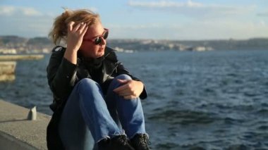 Seaside.mov üzerinde oturan üzgün bir kadın portresi