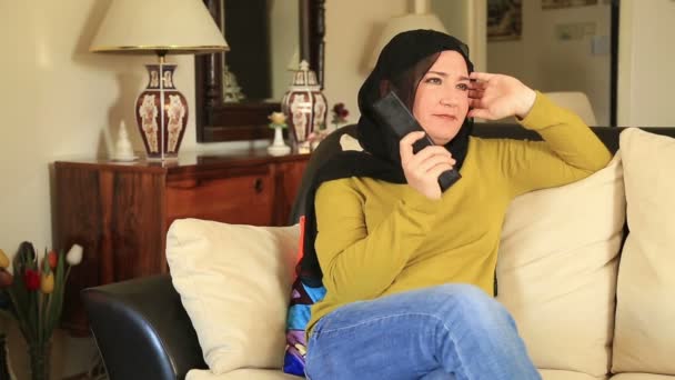 Мусульманка смотрит телевизор — стоковое видео