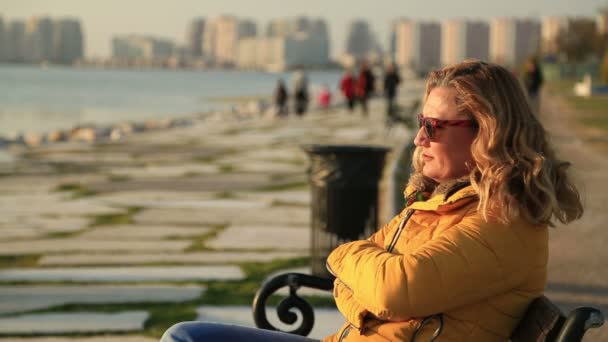 Portret van een vrouw die aan de kust zit — Stockvideo