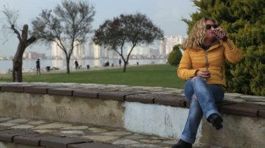 Parkta akıllı telefon kullanan kadın